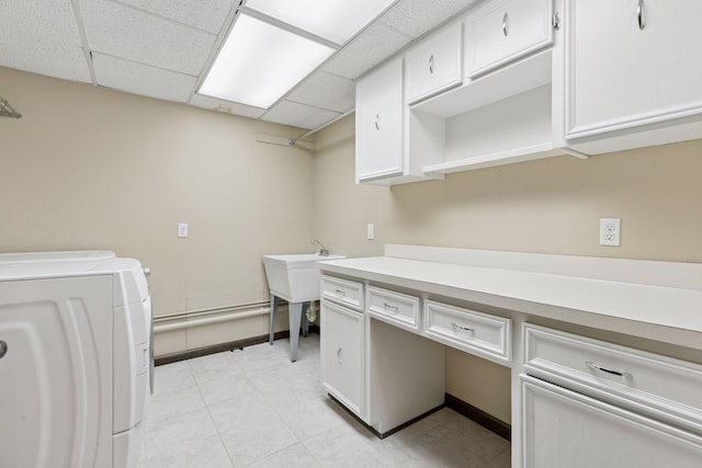 laundry area with washing machine and clothes dryer, cabinet space, and light tile patterned floors