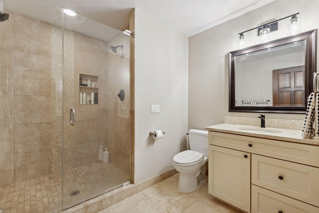full bathroom featuring a shower stall, toilet, baseboards, and vanity