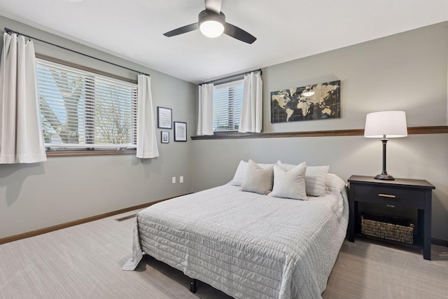 carpeted bedroom with a ceiling fan and baseboards