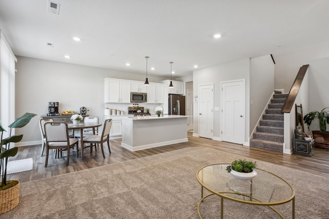 living area with light wood-style floors, stairway, recessed lighting, and baseboards