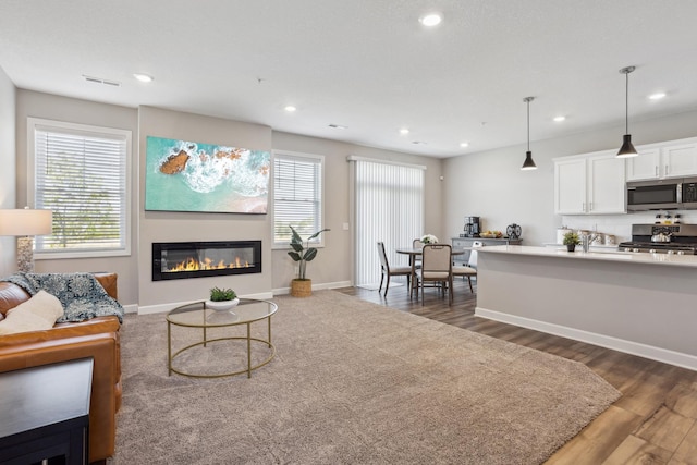 1836 Tyrone Dr, Shakopee, MN 55379 - living area with recessed lighting, dark wood finished floors, baseboards, and a glass covered fireplace