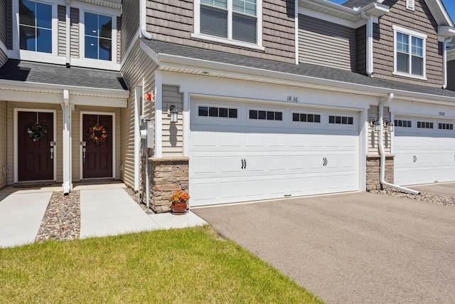 1836 Tyrone Dr, Shakopee, MN 55379 - view of exterior entry with a garage, driveway, stone siding, and roof with shingles