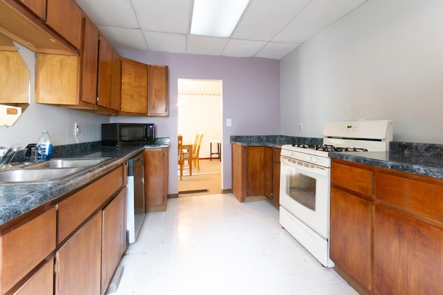 624 Main St, West Concord, MN 55985 - kitchen with gas range gas stove, black microwave, a sink, a paneled ceiling, and brown cabinets