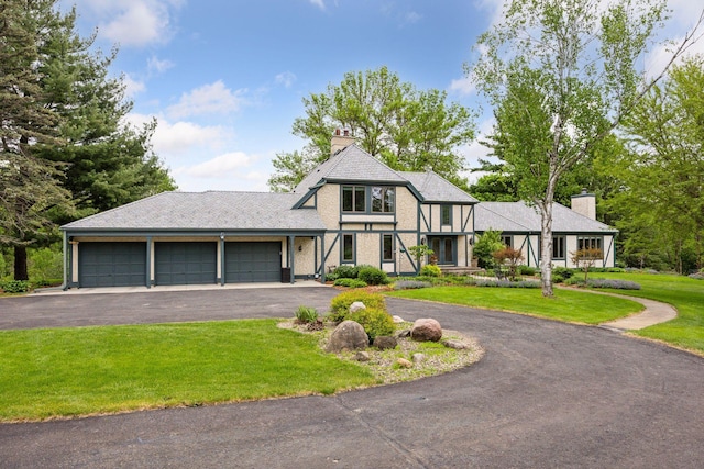 5510 Heather Dr SW, Rochester Twp, MN 55902 - view of front of house with an attached garage, a chimney, asphalt driveway, and a front lawn