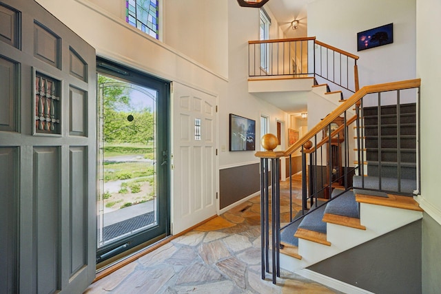 5510 Heather Dr SW, Rochester Twp, MN 55902 - foyer entrance with a towering ceiling, stairs, stone finish flooring, and baseboards