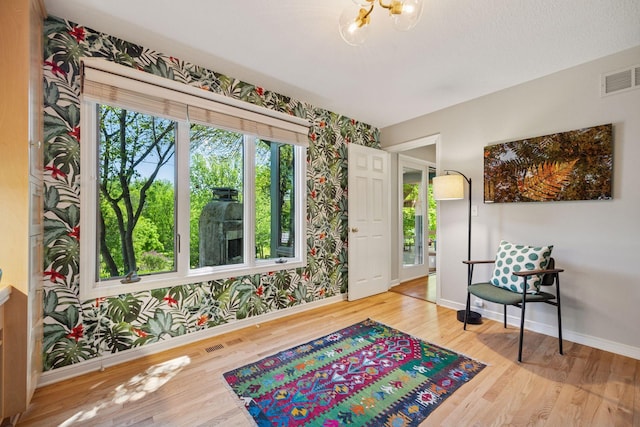 5510 Heather Dr SW, Rochester Twp, MN 55902 - sitting room featuring wallpapered walls, wood finished floors, baseboards, and a chandelier