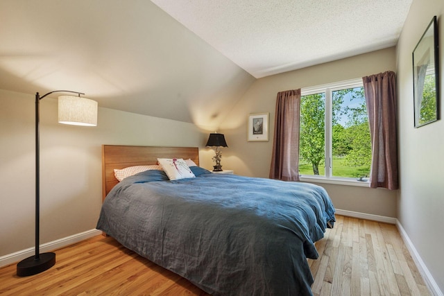 5510 Heather Dr SW, Rochester Twp, MN 55902 - bedroom featuring wood finished floors, baseboards, lofted ceiling, and a textured ceiling