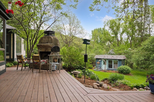 5510 Heather Dr SW, Rochester Twp, MN 55902 - wooden deck featuring an outdoor stone fireplace, a lawn, and an outdoor structure