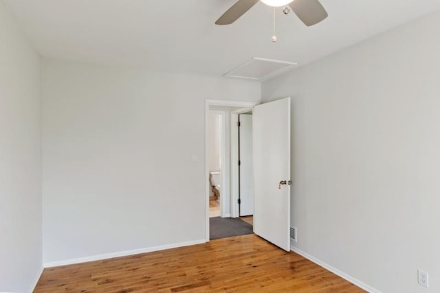 unfurnished room with ceiling fan, wood finished floors, and baseboards