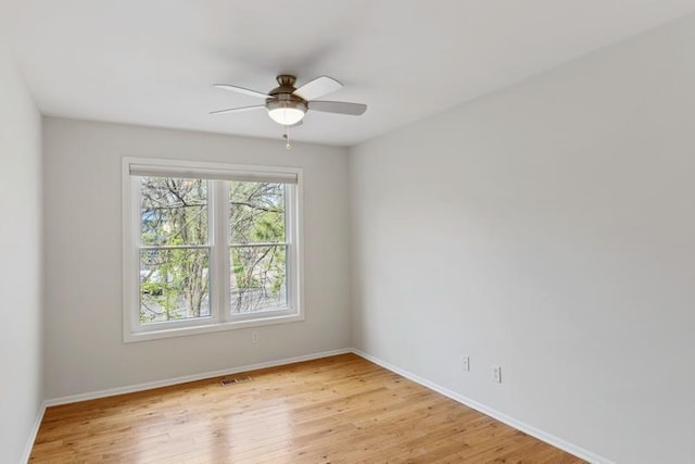 unfurnished room with light wood finished floors, baseboards, and a ceiling fan