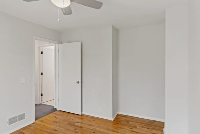 unfurnished bedroom featuring wood finished floors, baseboards, and a ceiling fan
