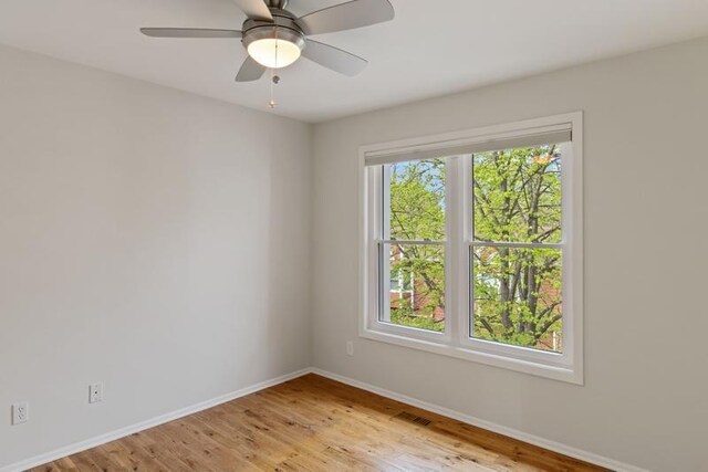 spare room with baseboards and light wood-style floors