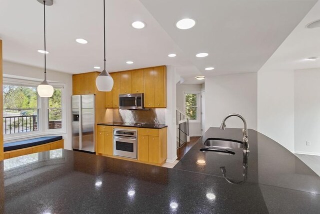 kitchen with appliances with stainless steel finishes, a sink, plenty of natural light, recessed lighting, and baseboards