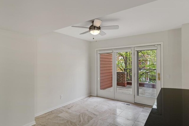 empty room with ceiling fan and baseboards