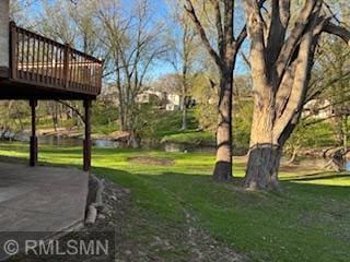 view of green lawn featuring a wooden deck