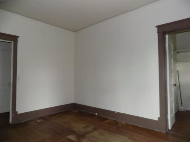 unfurnished bedroom featuring wood finished floors and baseboards