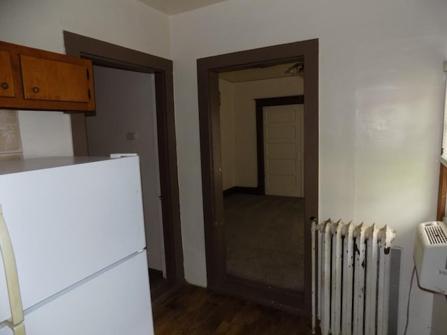 corridor with radiator heating unit and dark wood-type flooring