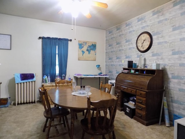 dining area with light carpet, radiator, and ceiling fan