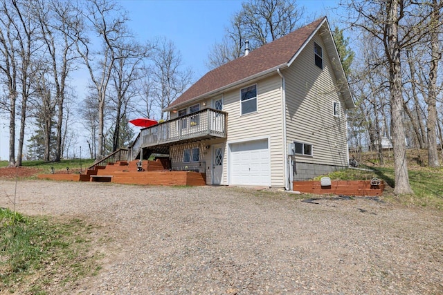 25185 Moreau Rd, Aitkin, MN 56431 - view of home's exterior with a deck, stairway, a garage, gravel driveway, and roof with shingles