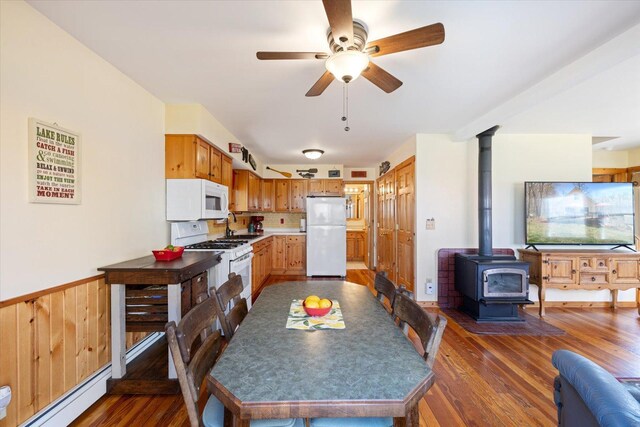 25185 Moreau Rd, Aitkin, MN 56431 - kitchen featuring white appliances, a wood stove, wood finished floors, ceiling fan, and open floor plan