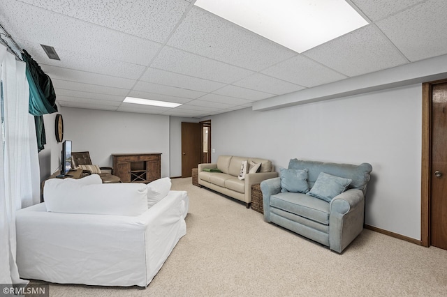 living area with a paneled ceiling, carpet, and a fireplace