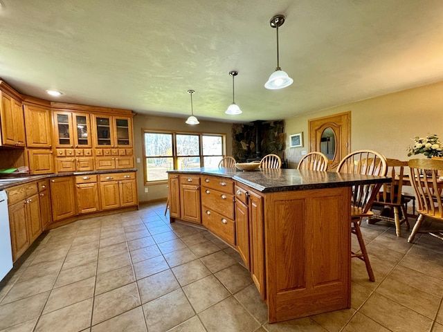 55715 State Highway 11, Warroad, MN 56763 - kitchen with brown cabinetry, a breakfast bar, dark countertops, and light tile patterned floors