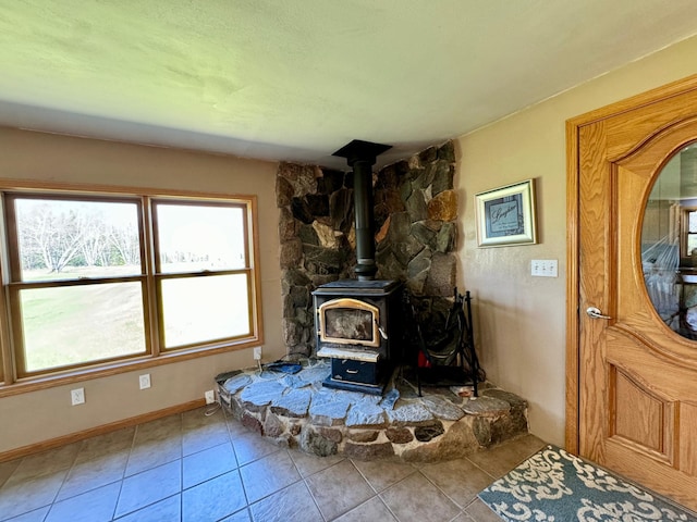 55715 State Highway 11, Warroad, MN 56763 - living area with tile patterned flooring, a wood stove, and baseboards