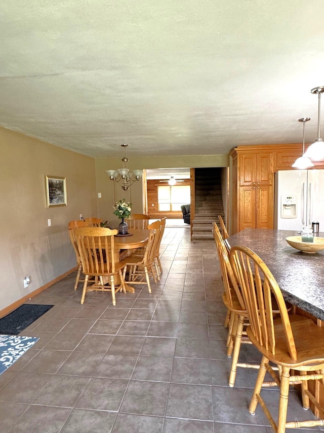 55715 State Highway 11, Warroad, MN 56763 - dining room featuring tile patterned flooring, stairs, baseboards, and a chandelier