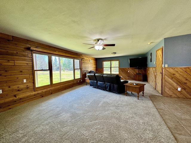 55715 State Highway 11, Warroad, MN 56763 - living room featuring wood walls, a textured ceiling, ceiling fan, carpet flooring, and a wainscoted wall