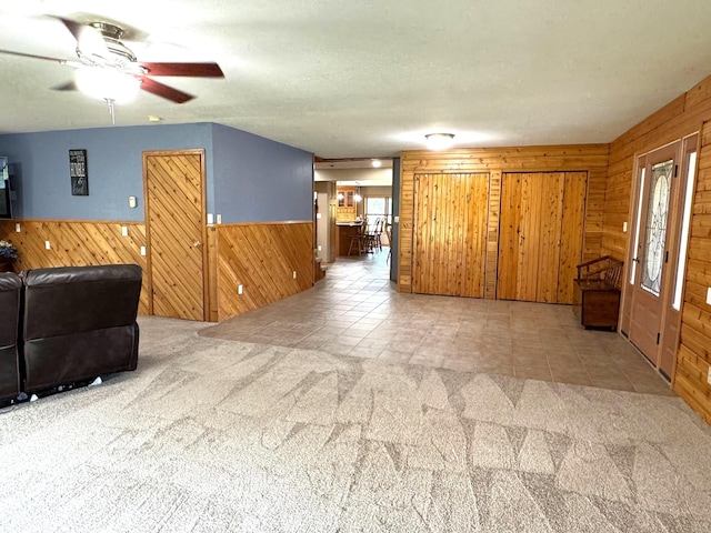 55715 State Highway 11, Warroad, MN 56763 - living room with wood walls, a ceiling fan, a wainscoted wall, and carpet floors