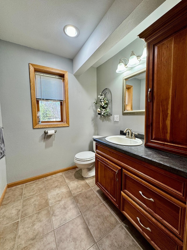 55715 State Highway 11, Warroad, MN 56763 - bathroom with toilet, baseboards, tile patterned floors, and vanity