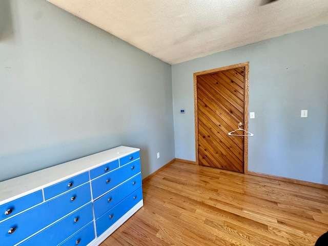 55715 State Highway 11, Warroad, MN 56763 - unfurnished bedroom featuring light wood-style flooring, baseboards, and a textured ceiling