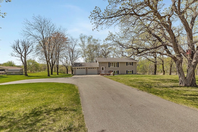view of front facade featuring asphalt driveway, an attached garage, and a front yard