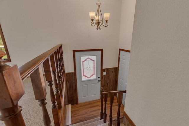 entrance foyer featuring wainscoting, healthy amount of natural light, wood finished floors, and a chandelier