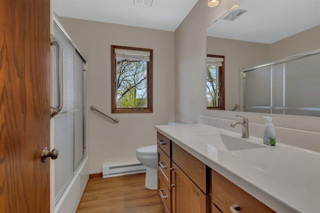 full bathroom featuring baseboard heating, an enclosed shower, wood finished floors, and vanity