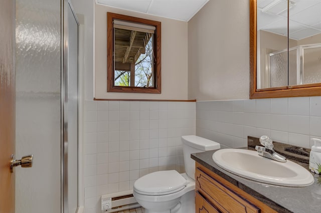 full bathroom with tile walls, a baseboard heating unit, a stall shower, vanity, and toilet