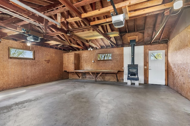 garage with a garage door opener and a wood stove