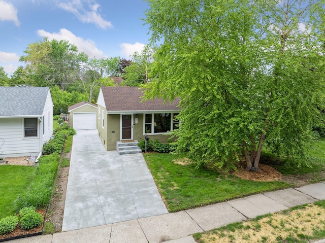 805 California Ave W, Saint Paul, MN 55117 - view of front facade with a detached garage, a front yard, an outdoor structure, roof with shingles, and concrete driveway