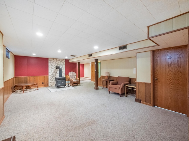 116 California Ave, Morris, MN 56267 - living area featuring a wood stove, wooden walls, carpet, a wainscoted wall, and recessed lighting