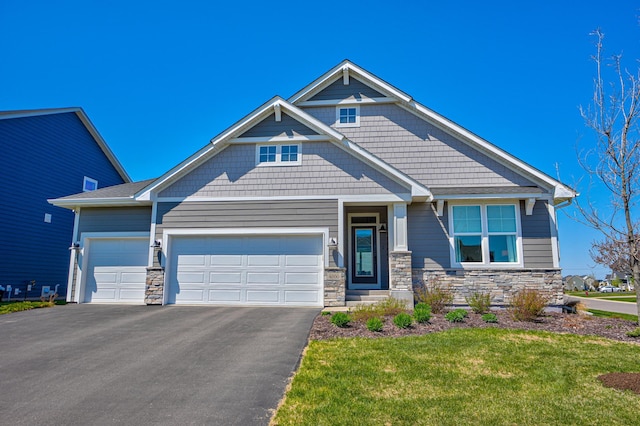 craftsman house featuring asphalt driveway, stone siding, a garage, and a front lawn