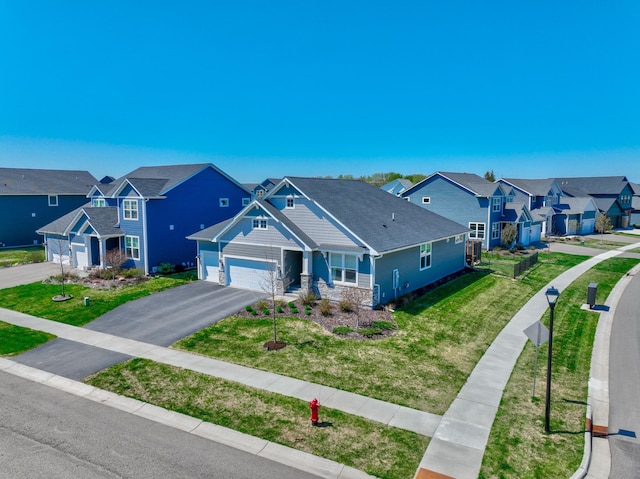view of front of house featuring a residential view, driveway, a garage, a front lawn, and stone siding
