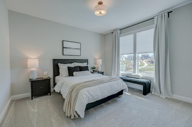 bedroom featuring light carpet and baseboards