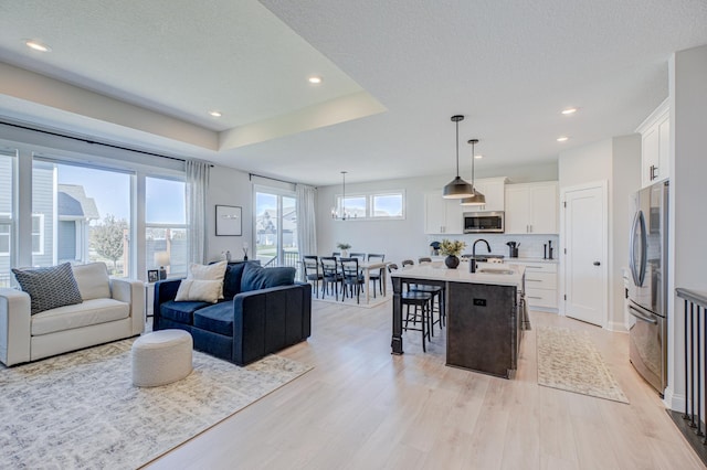 living room with light wood-type flooring, recessed lighting, and a textured ceiling