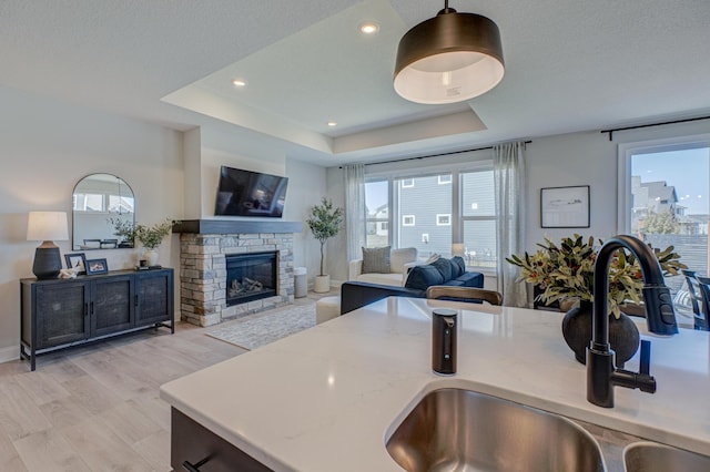 kitchen with a sink, healthy amount of natural light, a tray ceiling, and recessed lighting