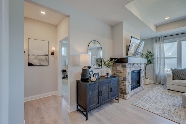 living area with light wood-style floors, a fireplace, and baseboards