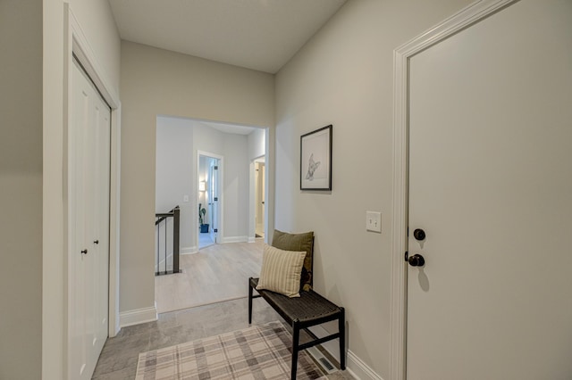 hall with an upstairs landing and baseboards