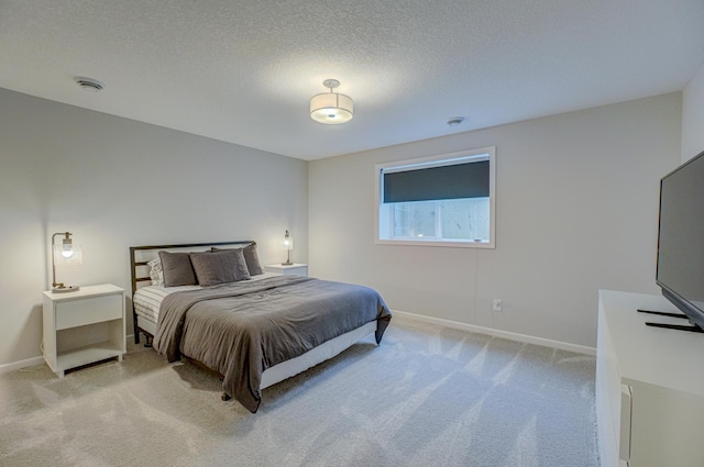 bedroom featuring light colored carpet, baseboards, and a textured ceiling