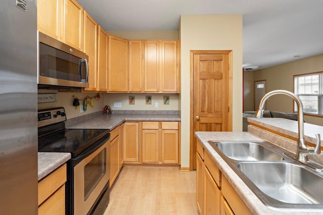 16322 70th Ave N Unit 304, Maple Grove, MN 55311 - kitchen featuring stainless steel appliances, a sink, light brown cabinets, and light wood finished floors