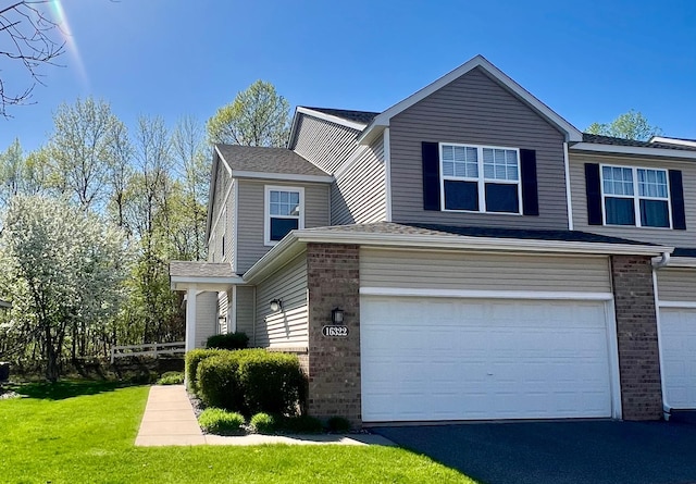 16322 70th Ave N Unit 304, Maple Grove, MN 55311 - view of front of property with a garage, brick siding, asphalt driveway, and roof with shingles
