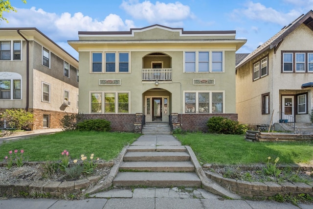 3441 Portland Ave Unit 1, Minneapolis, MN 55407 - view of front of home featuring stucco siding, a front yard, a balcony, and brick siding